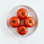 Bright red tomatoes in a ceramic bowl, perfect for healthy recipes.